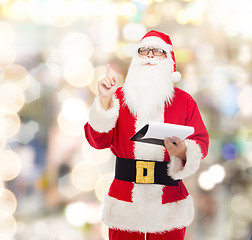 Image showing man in costume of santa claus with notepad