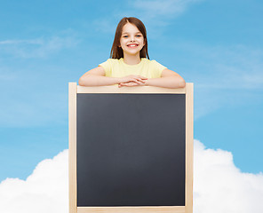 Image showing happy little girl with blank blackboard