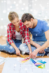 Image showing smiling couple selecting color from samples