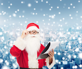 Image showing man in costume of santa claus with notepad