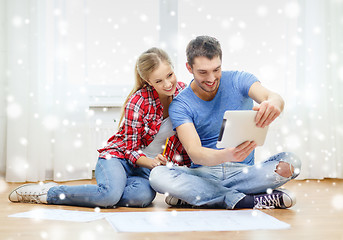 Image showing smiling couple with tablet and blueprint at home