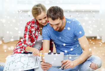 Image showing smiling couple with tablet and blueprint at home