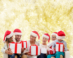 Image showing happy family in santa helper hats with gift boxes