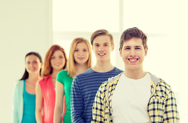 Image showing smiling students with teenage boy in front