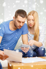 Image showing busy couple with papers and calculator at home