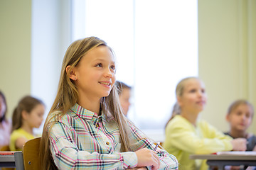 Image showing group of school kids with notebooks in classroom