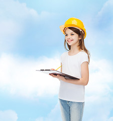 Image showing smiling little girl in hardhat with clipboard