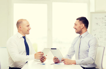 Image showing two smiling businessmen with tablet pc in office