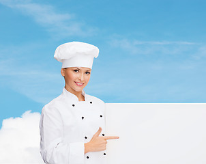 Image showing smiling female chef with white blank board