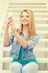 Image showing smiling female student with smartphone