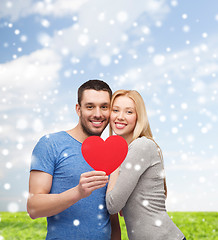 Image showing happy couple with red heart shape hugging outdoors