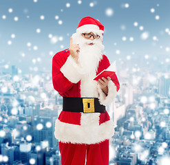 Image showing man in costume of santa claus with notepad