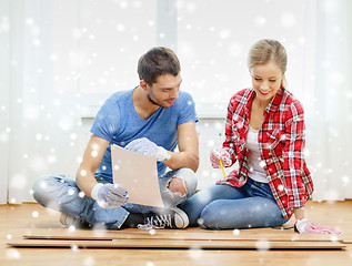 Image showing smiling couple measuring wood flooring