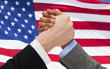 Image showing close up of hands arm wrestling over american flag