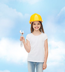 Image showing smiling little girl in hardhat with wrench