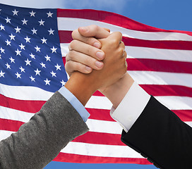 Image showing close up of hands armwrestling over american flag