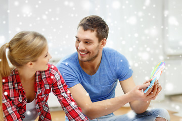 Image showing smiling couple selecting color from samples