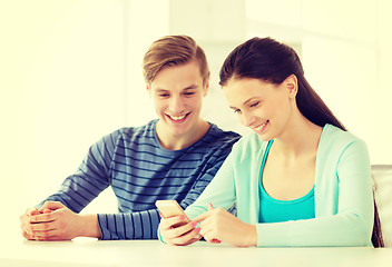 Image showing two smiling students with smartphone at school