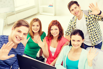 Image showing group of smiling students waving hands at school