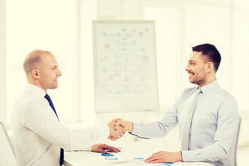 Image showing two smiling businessmen shaking hands in office