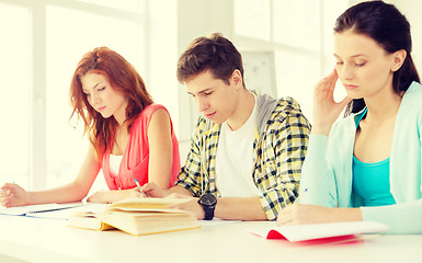 Image showing tired students with textbooks and books at school