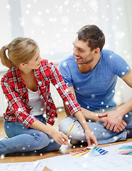 Image showing smiling couple selecting color from samples