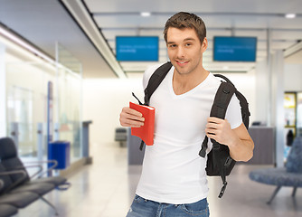 Image showing smiling student with backpack and book at airport