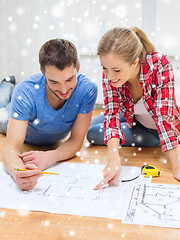 Image showing smiling couple with blueprint at home