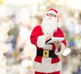 Image showing man in costume of santa claus with notepad