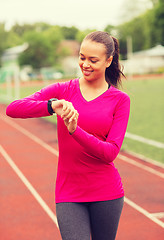 Image showing smiling young woman with heart rate watch