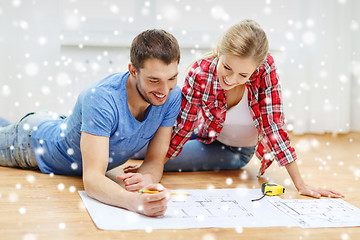 Image showing smiling couple with blueprint at home