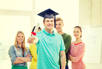 Image showing smiling male student with diploma and corner-cap