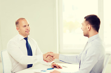 Image showing two smiling businessmen shaking hands in office