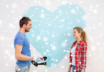 Image showing smiling couple painting big heart on wall