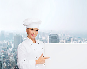 Image showing smiling female chef with white blank board