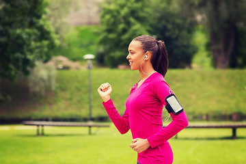 Image showing smiling young woman running outdoors