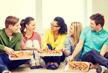 Image showing five smiling teenagers eating pizza at home