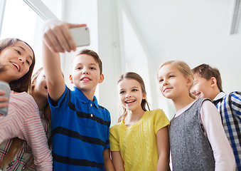 Image showing group of school kids taking selfie with smartphone