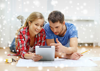 Image showing smiling couple with tablet pc at home