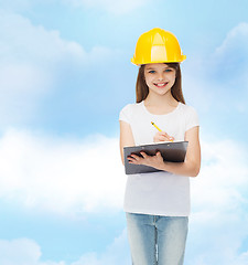 Image showing smiling little girl in hardhat with clipboard