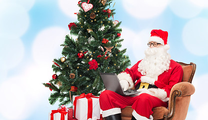 Image showing man in costume of santa claus with laptop