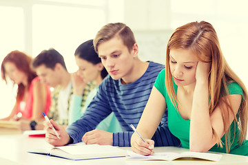 Image showing tired students with textbooks and books at school