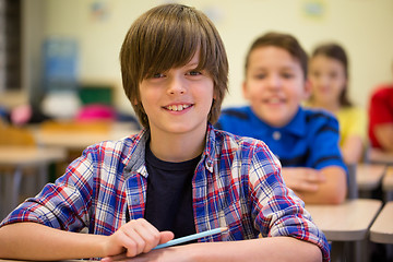 Image showing group of school kids with notebooks in classroom