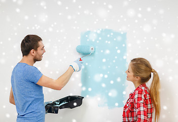 Image showing smiling couple with roll and tray painting wall