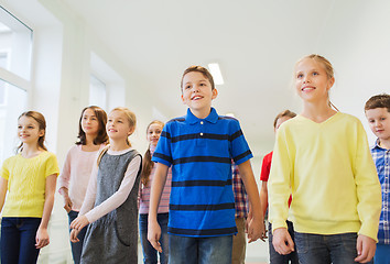 Image showing group of smiling school kids walking in corridor