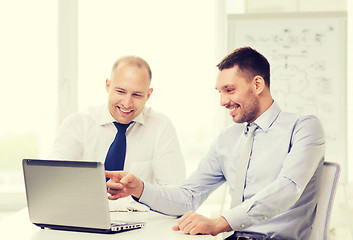 Image showing two smiling businessmen with laptop in office