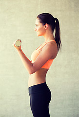 Image showing smiling woman with dumbbells in gym