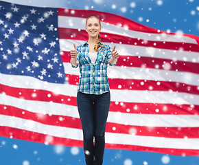 Image showing smiling girl in casual clothes showing thumbs up