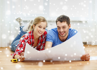 Image showing smiling couple with blueprint at home