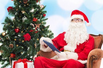 Image showing man in costume of santa claus with tablet pc